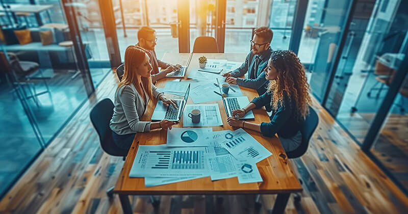 Professionals working together and strategizing around a large conference table.