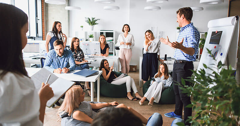 Man presents data to in-house team.